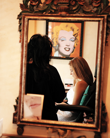 The bride has her hair and makeup done at a salon in Pennsylvania, with Marilyn Monroe looking over her