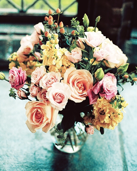 A beautiful bouquet of flowers, include pink and peach roses, and yellow flowers, compliment the fall wedding
