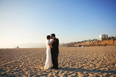 The bride and groom kiss on the beach after their Los Angeles wedding