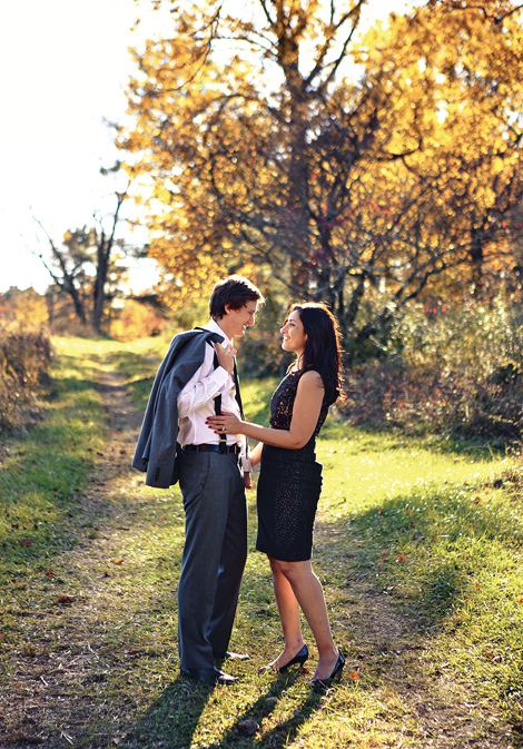 A couple walks together on a beautiful, sunny fall day at the Tyler Arboretum for their elegant engagement photos