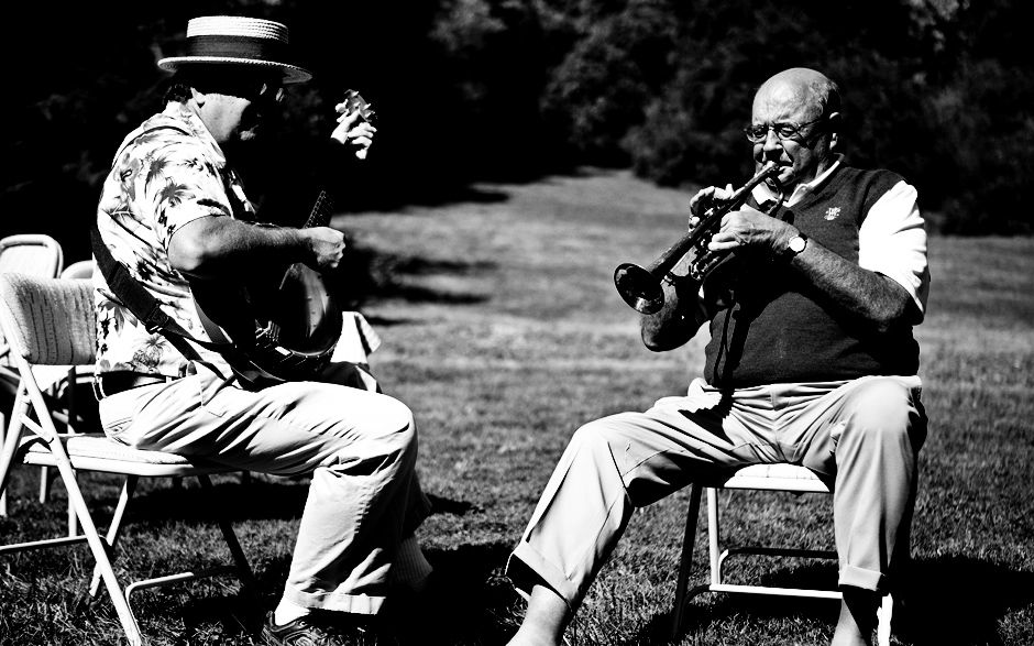 Grandfathers play the banjo and trumpet at their family reunion before the wedding