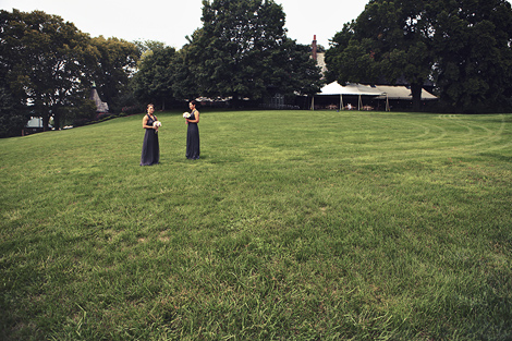 Two bridesmaids, wearing gray gowns, stand outside at Greenville Country Club