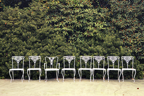 White wrought iron chairs are lined up at Greenville Country Club for the wedding