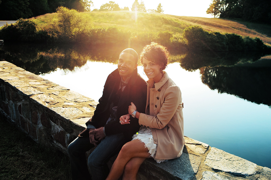 The copule sits by a pond in the setting sun at Winterthur for these beautiful engagement photos, photographed by Peter Van Beever