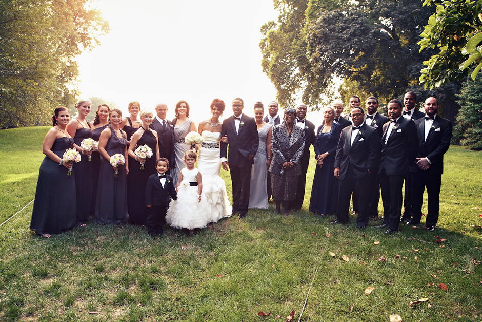 The bridal party poses for a group shot in the setting sun at Greenville Country Club