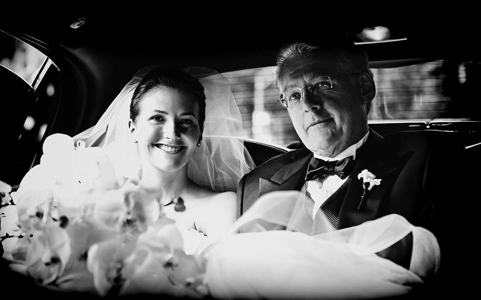 The bride poses with her father in the back of the limo on her wedding day
