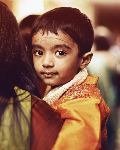 A little boy in waits with his parents at an Indian wedding in Atlanta, Georgia