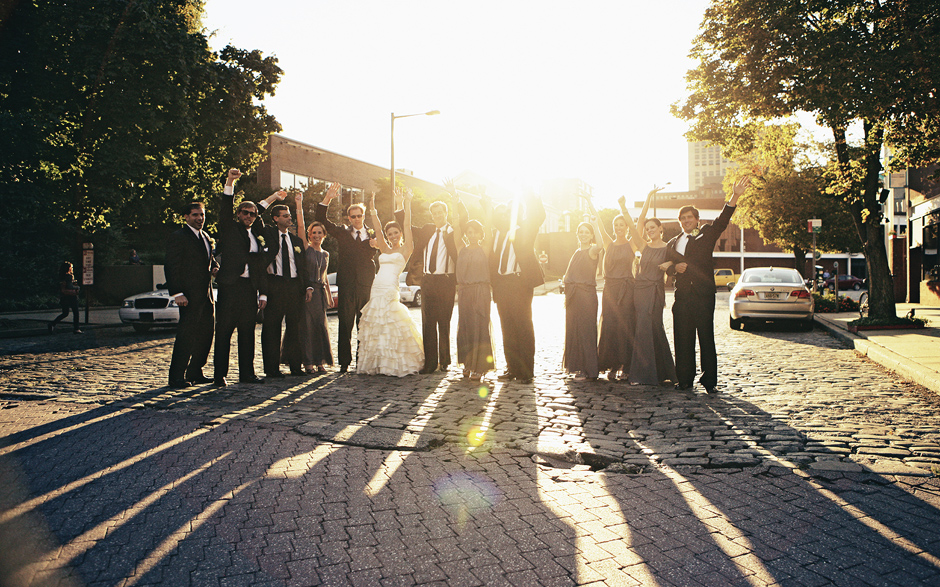 A bridal party poses for group shots on a cobblestone city street in old town Philadelphia at sunset, photo by Peter Van Beever Weddings