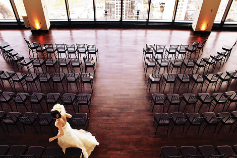 The bride walks amongst the chairs before the ceremony at the State Room in Boston