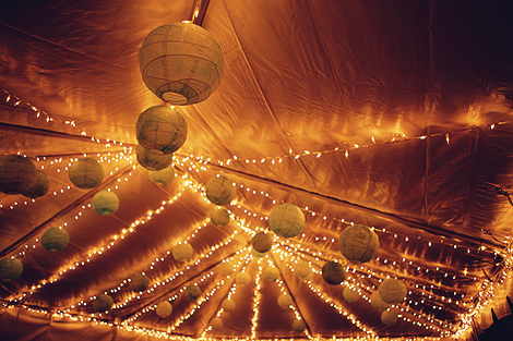 Lanterns and strung lights make this outdoor tent wedding reception look elegant and understated