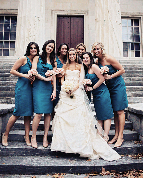 The bride poses with her bridesmaids, wearing blue cocktail dresses, on the steps of the bank building in Philadelphia