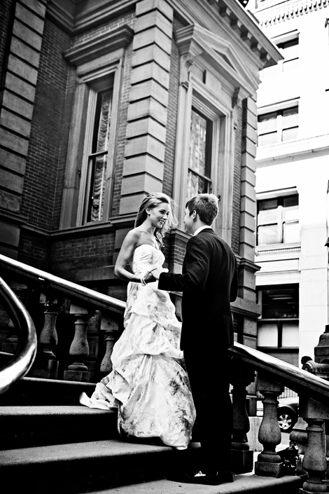 The bride and groom hold hands on the steps of the Union League Philadelphia before their wedding