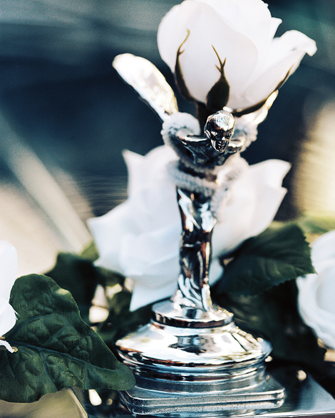 The front detail of the vintage car is wrapped with roses and flowers for the bride and groom's send off