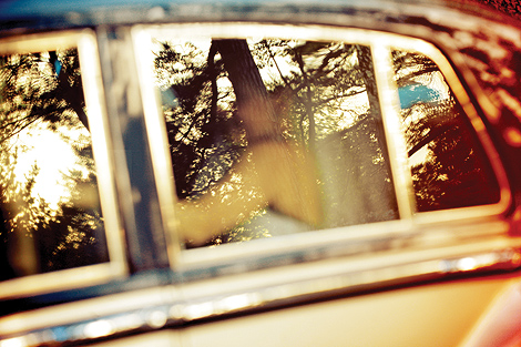 The bride and groom sit in this vintage car on a beautiful and sunny fall day after their wedding ceremony at the Aldie Mansion