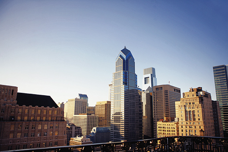 Liberty Place stands tall against the Philadelphia skyline from the balcony of XIX restaurant for this couple's engagement shoot