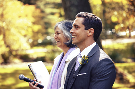 The groom smiles, while waiting for the bride to walk down the aisle at their summer wedding at Appleford Estate