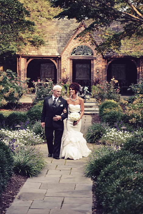 The bride looks beautiful walking down the aisle with her father at Greenville Country Club for her summer wedding