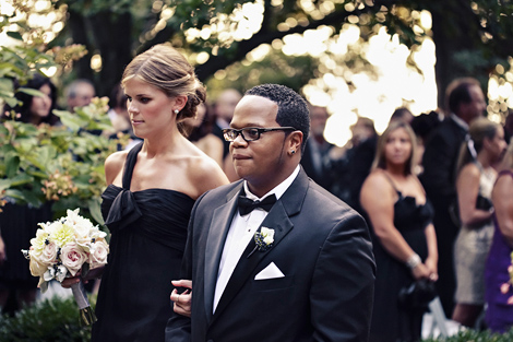 The maid of honor and best man walk up the aisle after the outdoor ceremony at Greenville Country Club