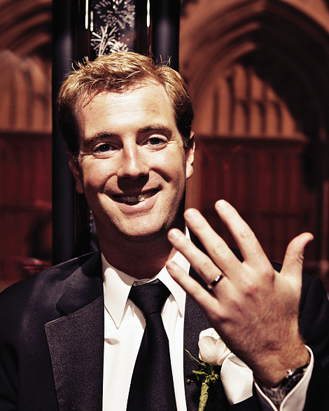 The groom shows off his new gold wedding band while riding the party bus in philadelphia.