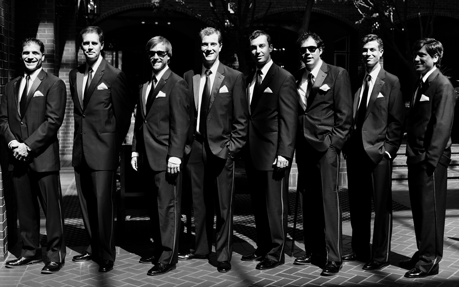 Black and white posed group shot of the groomsen at a wedding inside the lobby of the Sheraton Society Inn Hotel in Philadelphia.