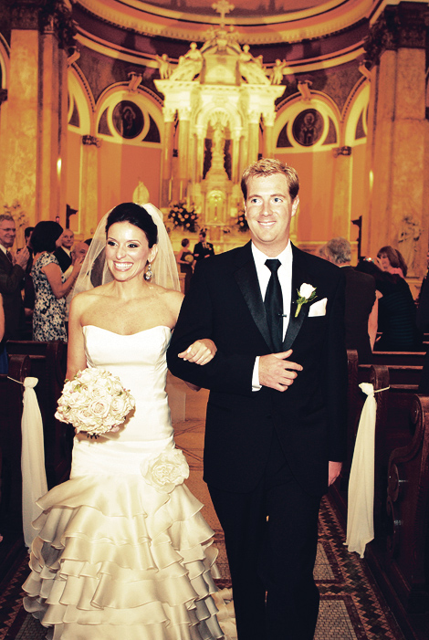 At the end of the ceremony, a bride and groom smile at guests as they exit the saint rita cathedral in philadelphia. 