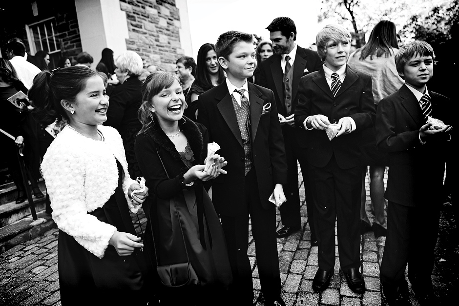 A group of children gather outside the church to throw flowers on the bride and groom as they leave the church