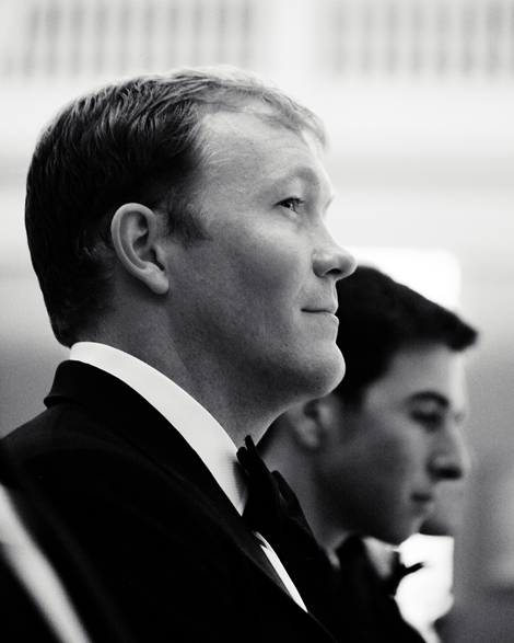 A groomsman wearing a tux waits for the ceremony to start