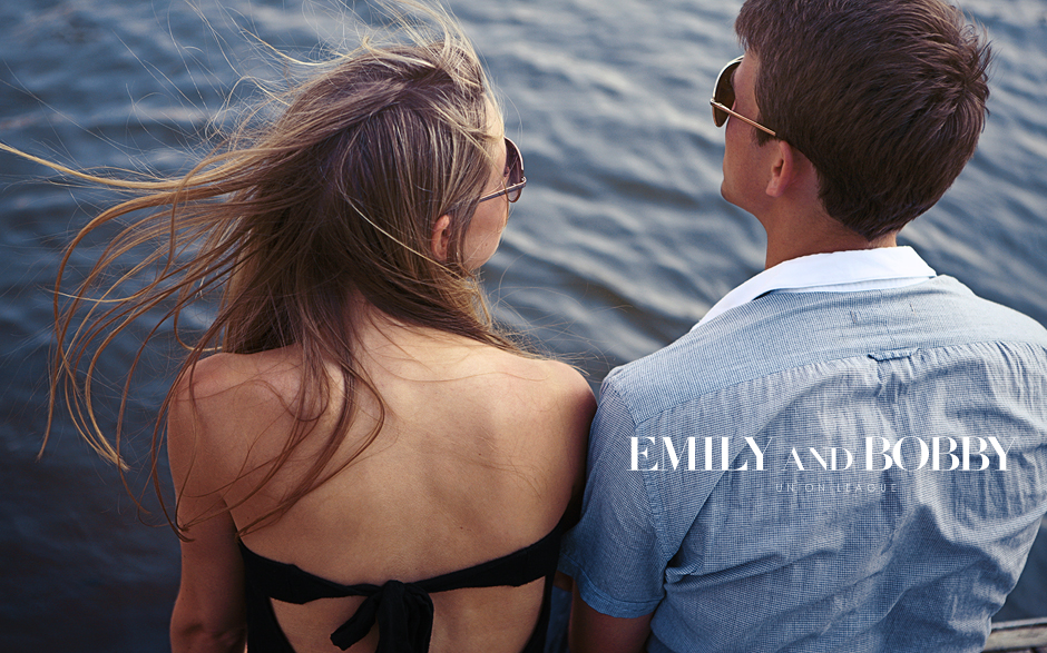 A couple sits with their legs dangling over a dock on the Schuylkill River on boathouse row in Philadelphia, PA for this classy and elegant engagement shoot, photographed by Peter Van Beever